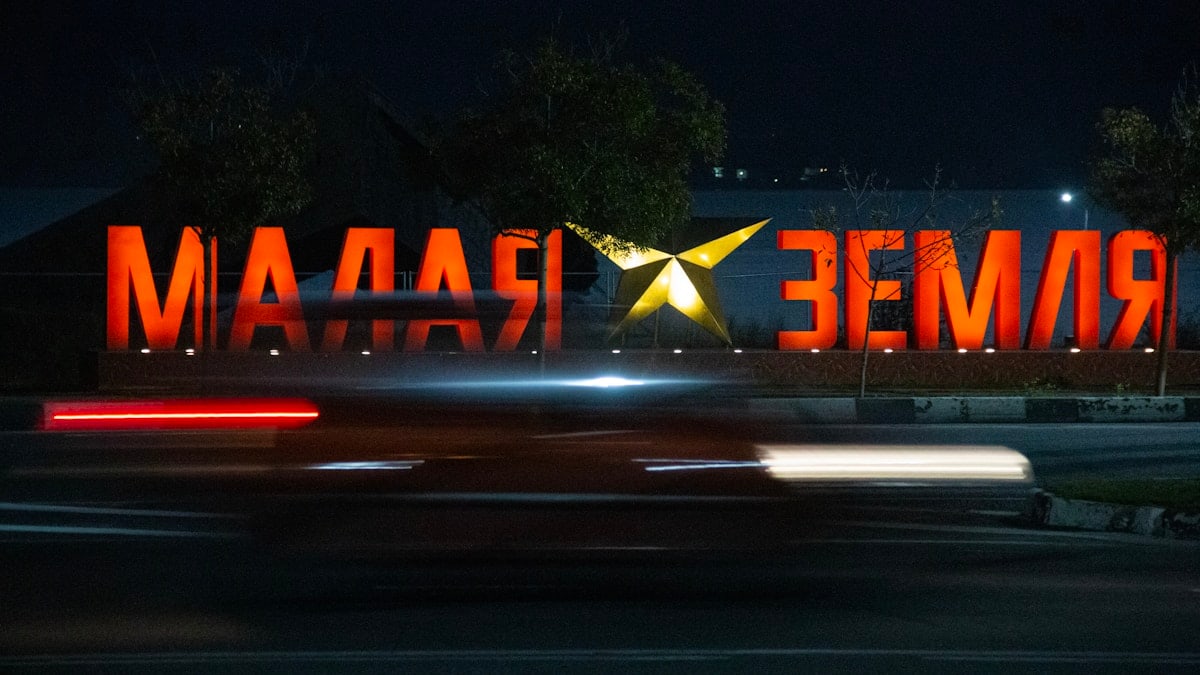 Large illuminated sign at night with light streaks